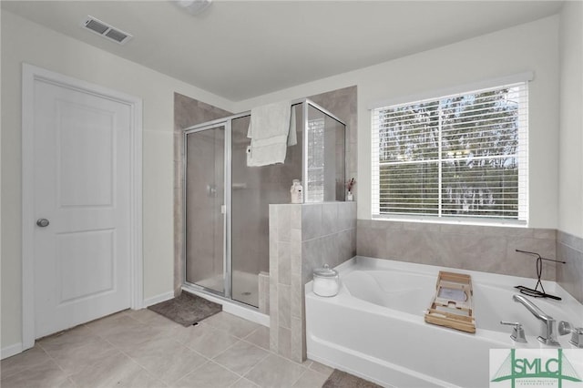 bathroom with separate shower and tub and tile patterned flooring