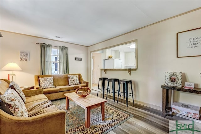 living room with hardwood / wood-style floors and crown molding