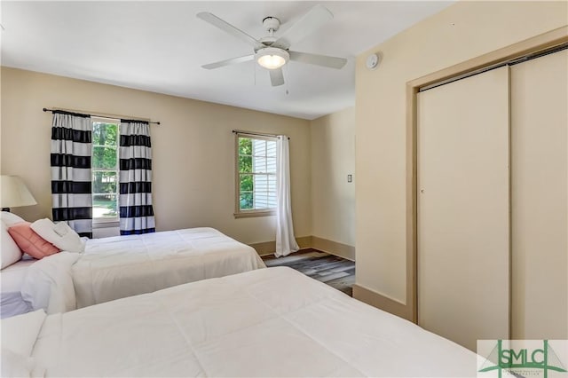 bedroom featuring ceiling fan, wood-type flooring, and a closet