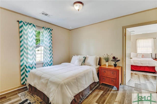 bedroom with crown molding and wood-type flooring