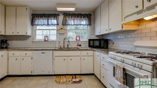 kitchen with backsplash, sink, light tile patterned floors, and white appliances