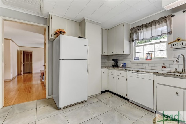 kitchen featuring white appliances, white cabinets, sink, tasteful backsplash, and light tile patterned flooring