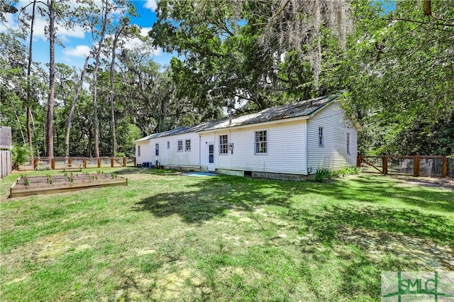 rear view of property with a lawn