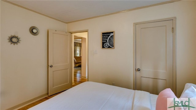 bedroom with crown molding and wood-type flooring