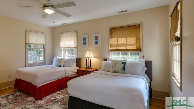 bedroom featuring multiple windows, ceiling fan, and hardwood / wood-style flooring