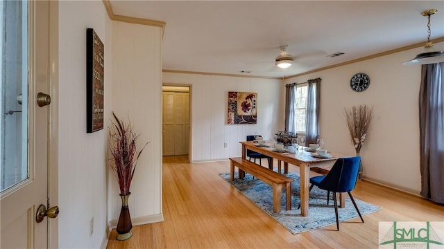 dining room with ceiling fan, crown molding, and light hardwood / wood-style flooring