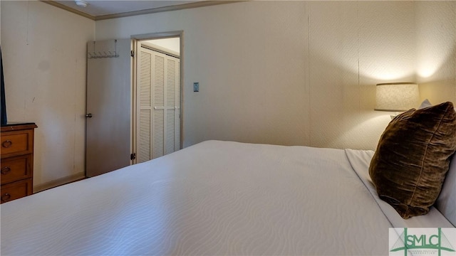 bedroom with a closet and crown molding