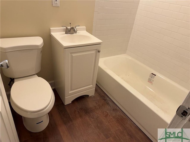 bathroom with hardwood / wood-style floors, vanity, a bath, and toilet