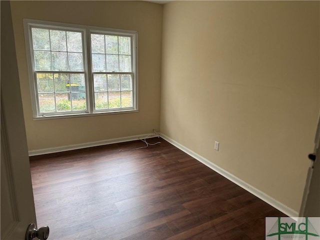 empty room with plenty of natural light and dark hardwood / wood-style flooring