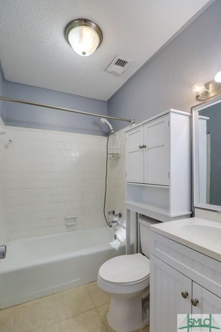 full bathroom with tiled shower / bath combo, tile patterned floors, a textured ceiling, toilet, and vanity