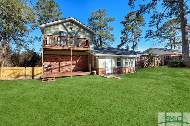 rear view of house with a yard and a wooden deck