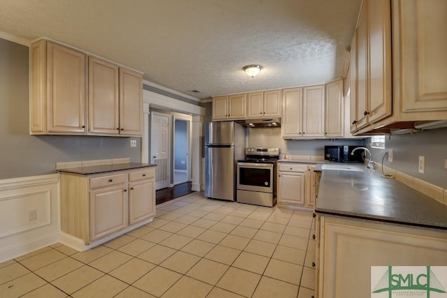 kitchen with appliances with stainless steel finishes, a textured ceiling, crown molding, sink, and light tile patterned floors