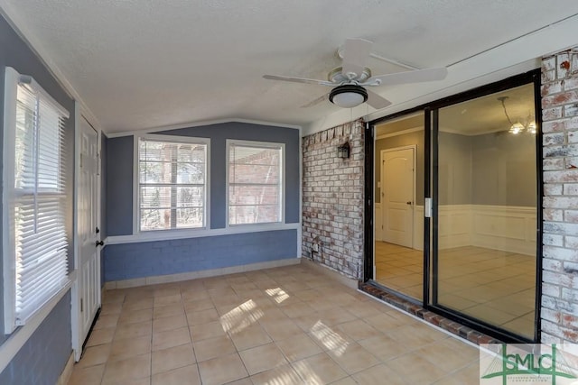 unfurnished sunroom featuring ceiling fan and vaulted ceiling