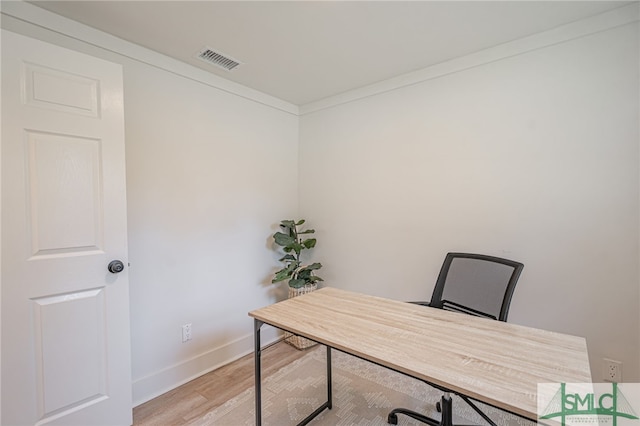 office area with light wood-type flooring and crown molding