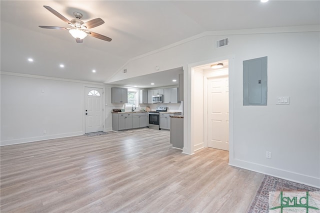 unfurnished living room with ceiling fan, electric panel, crown molding, vaulted ceiling, and light wood-type flooring