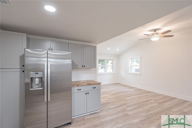 kitchen featuring stainless steel refrigerator with ice dispenser, ceiling fan, gray cabinets, light hardwood / wood-style flooring, and butcher block countertops