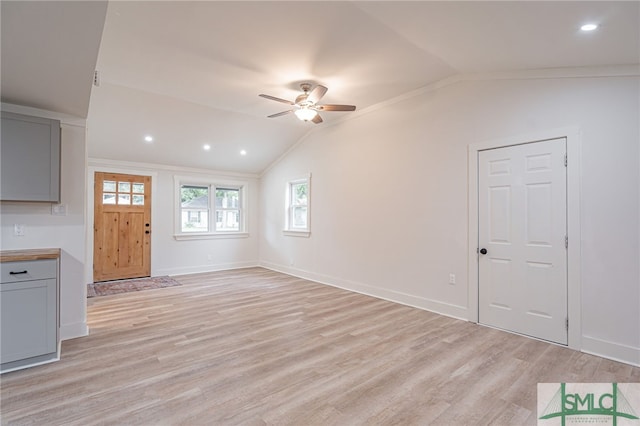 unfurnished living room featuring ceiling fan, light hardwood / wood-style flooring, crown molding, and lofted ceiling