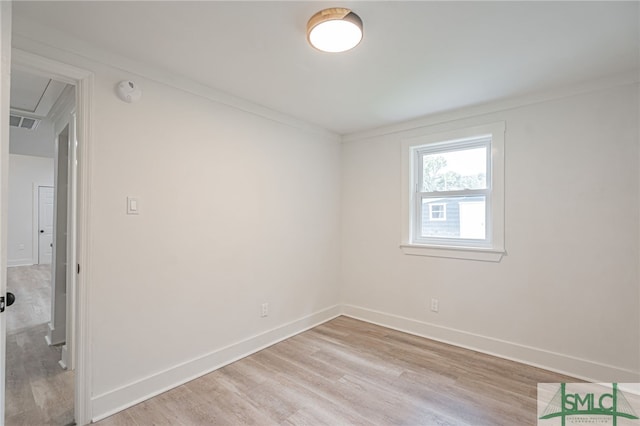 empty room with light hardwood / wood-style flooring and ornamental molding