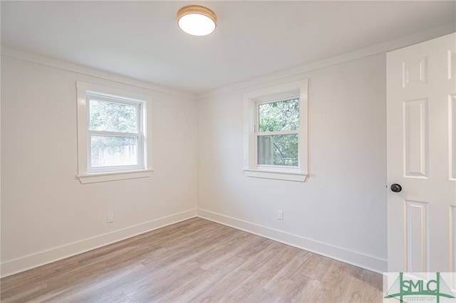 empty room featuring light hardwood / wood-style floors and ornamental molding