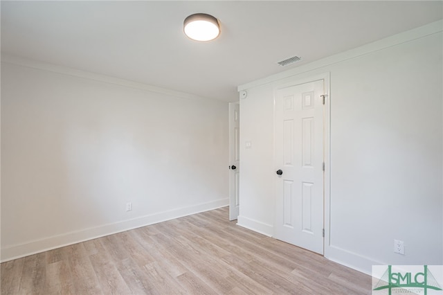 spare room featuring light hardwood / wood-style flooring and ornamental molding