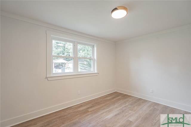 spare room featuring light wood-type flooring and ornamental molding