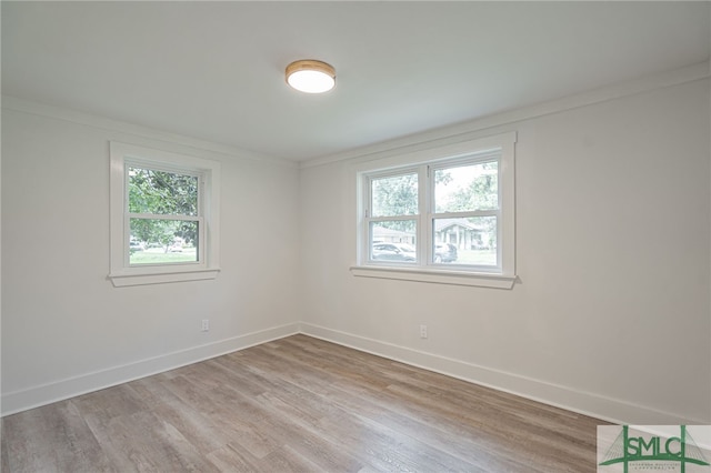 empty room with light hardwood / wood-style flooring and ornamental molding