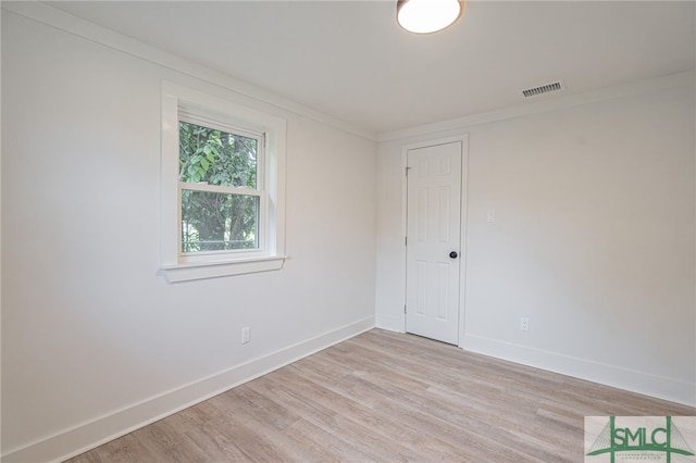 unfurnished room featuring light hardwood / wood-style flooring and crown molding