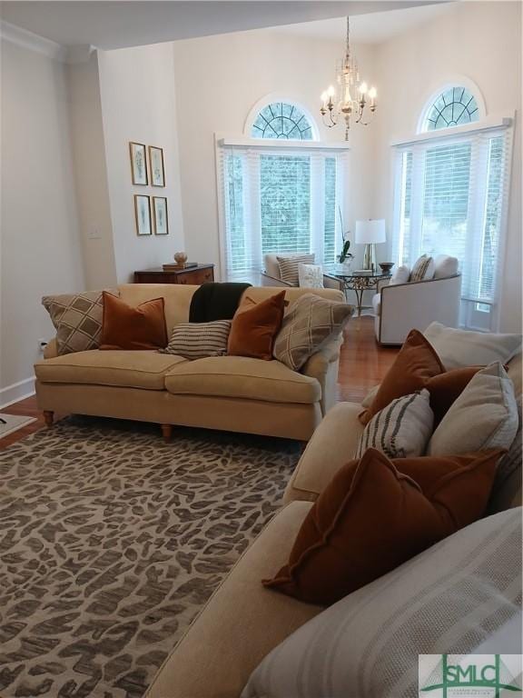 living room featuring wood-type flooring, a healthy amount of sunlight, and a notable chandelier