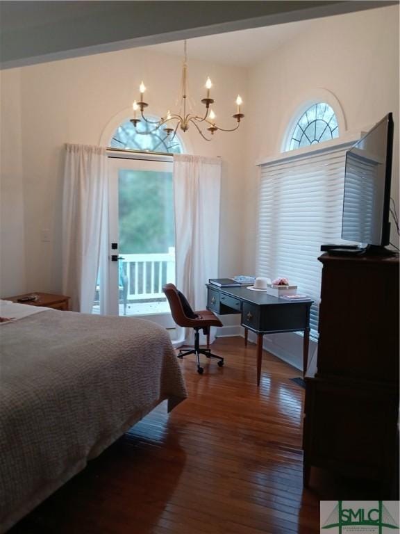 bedroom featuring multiple windows, wood-type flooring, and a notable chandelier