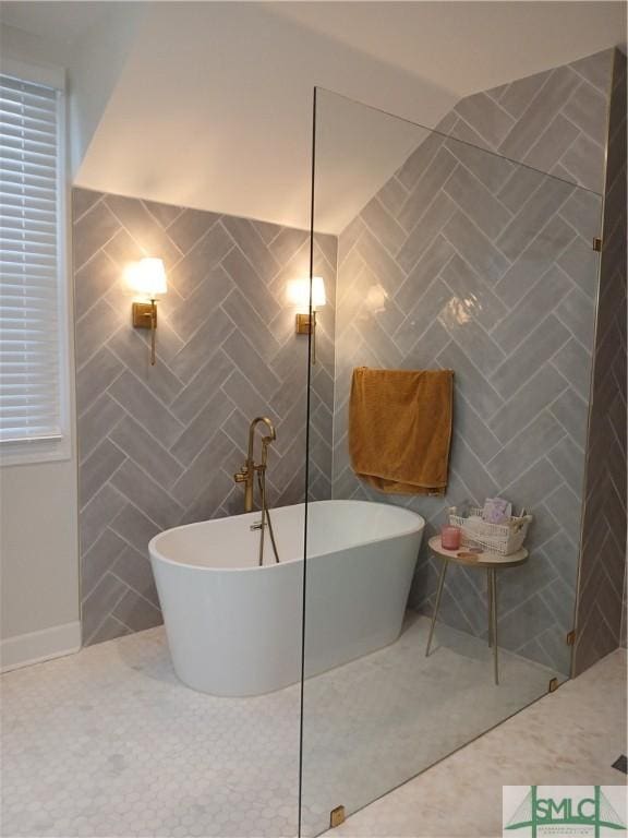 bathroom with a bathtub and tile walls