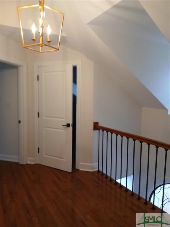 bonus room with dark hardwood / wood-style floors and a notable chandelier