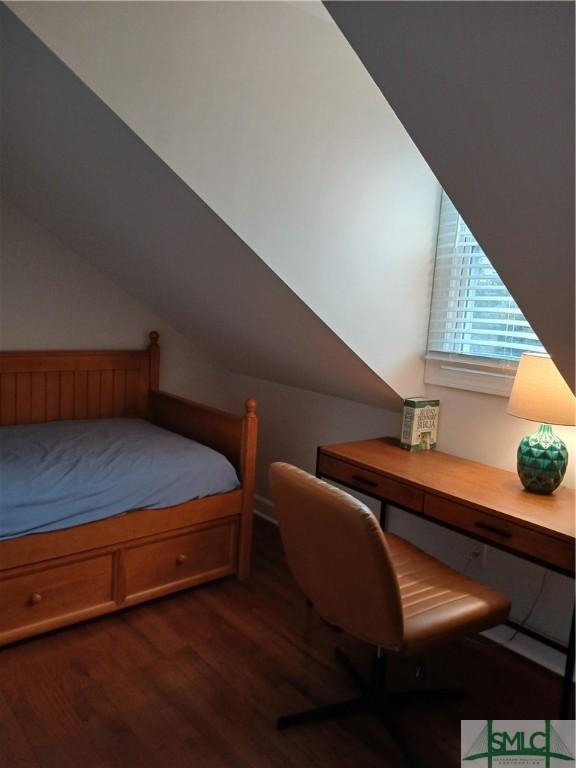 bedroom featuring dark hardwood / wood-style flooring and lofted ceiling