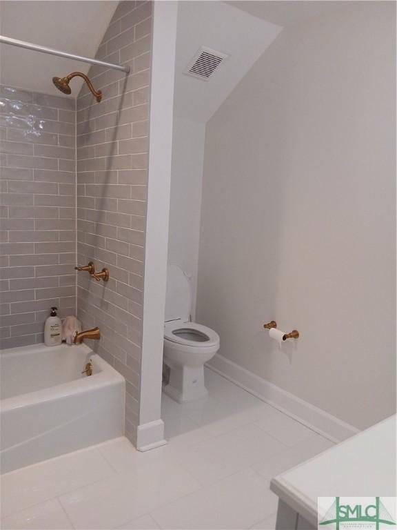 bathroom with toilet, tile patterned floors, and tiled shower / bath