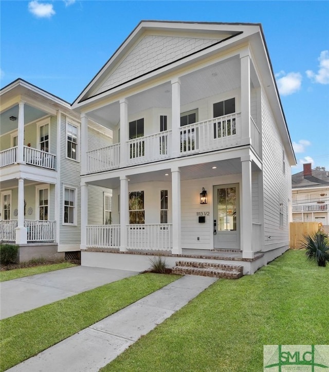 neoclassical home featuring a front lawn