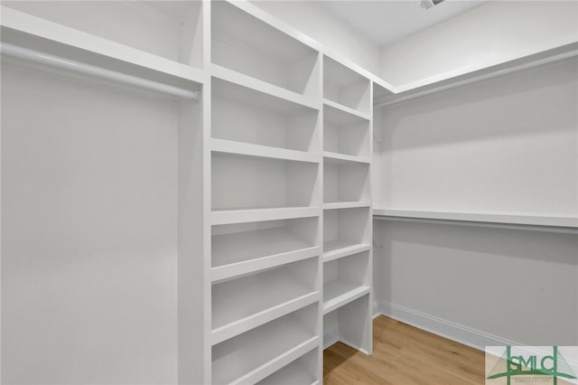 spacious closet with hardwood / wood-style flooring