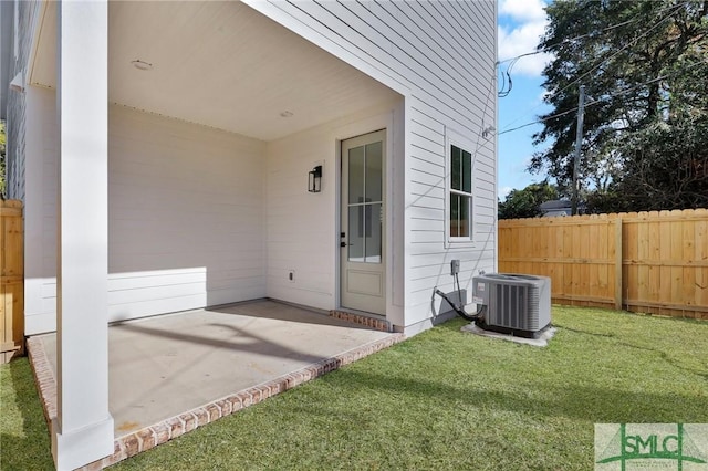 property entrance featuring a patio, cooling unit, and a lawn