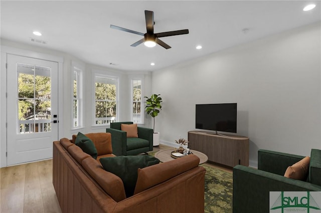 living room with ceiling fan and light wood-type flooring