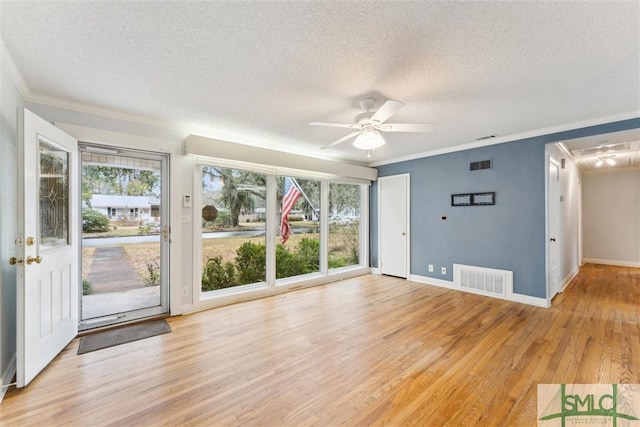 interior space with a wealth of natural light, crown molding, and light wood-type flooring