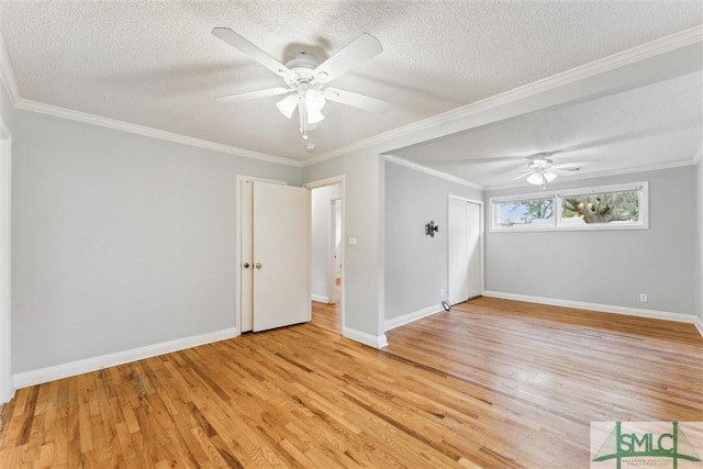 empty room featuring light wood-type flooring, ornamental molding, and a textured ceiling