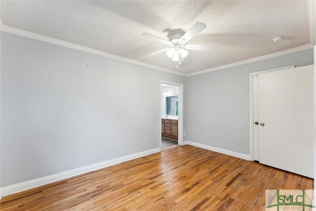 empty room with wood-type flooring, a textured ceiling, and ornamental molding