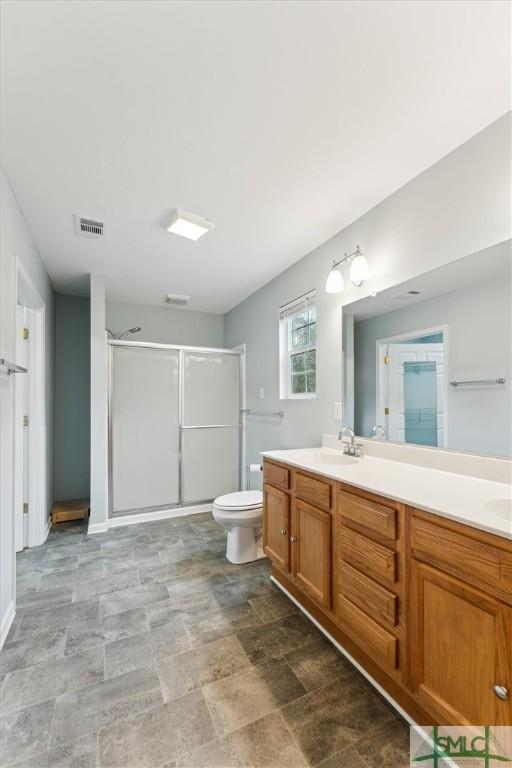 bathroom featuring toilet, vanity, and walk in shower