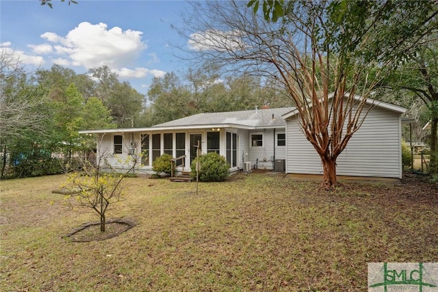 back of house with a sunroom, central air condition unit, and a lawn