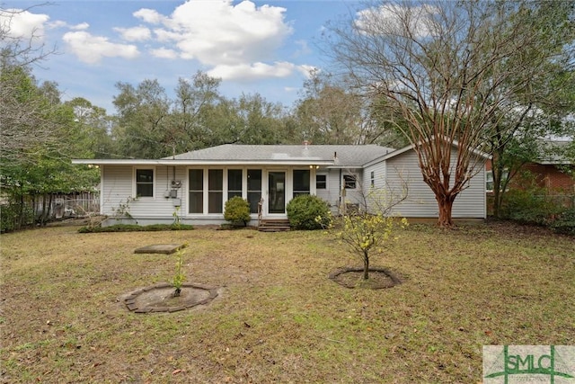 rear view of property with a lawn