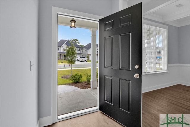 foyer entrance with beam ceiling, wood-type flooring, and ornamental molding