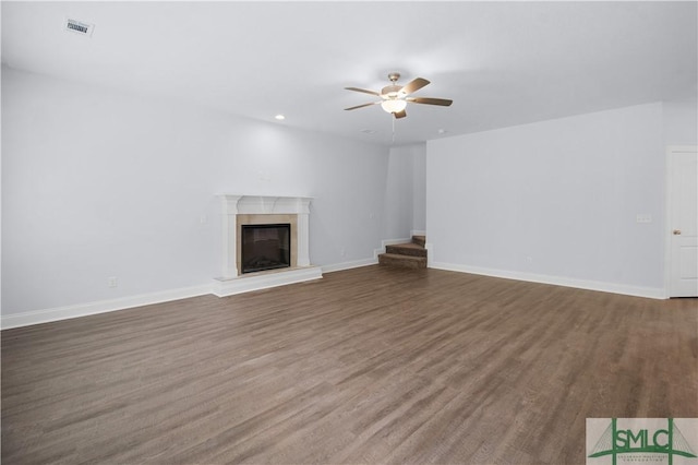 unfurnished living room with dark hardwood / wood-style flooring and ceiling fan