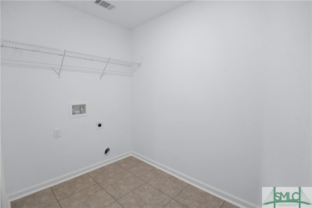 washroom with hookup for an electric dryer, hookup for a washing machine, and light tile patterned floors