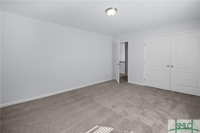 unfurnished bedroom with a closet and light colored carpet