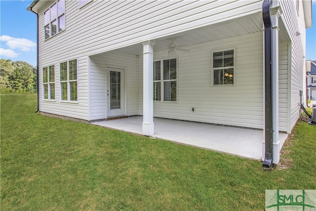 back of property featuring ceiling fan, a yard, and a patio