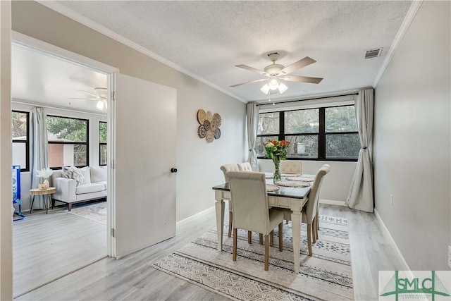 dining space featuring crown molding, ceiling fan, light hardwood / wood-style floors, and a textured ceiling