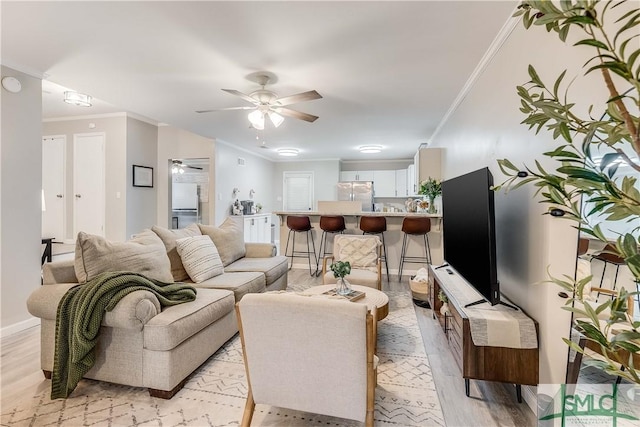 living room featuring ceiling fan, light hardwood / wood-style flooring, and ornamental molding